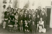 Mal-und Zeichenschule 1943/1944. Nauczyciele i uczniowie na tle prac z rysunku. Dyr Janina Miłosiowa (drugi rząd od dołu, piąta z lewej). Kliknięcie w miniaturkę obrazka spowoduje wyświetlenie powiększonego zdjęcia.