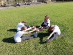 Uczniowie ćwiczą na trawie - rozgrzewka. Kliknięcie w miniaturkę obrazka spowoduje wyświetlenie powiększonego zdjęcia.