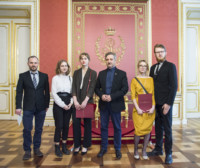 Stypendystki z dyplomami w rękach i osoby towarzyszące stoją przed tronem Stanisława Augusta Poniatowskiego. Kliknięcie spowoduje wyświetlenie powiększonego zdjęcia.