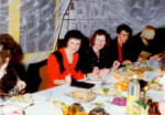 Nauczyciele siedzą przy stole zastawionym jedzeniem. Kliknięcie w miniaturkę obrazka spowoduje wyświetlenie powiększonego zdjęcia.