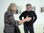 Na tle prac w galerii dyr Krzysztof Dąbek rozmawia z nauczycielką Małgorzatą Przygrodzką. Obok stoi Marzena Łukaszuk. Kliknięcie w miniaturkę obrazka spowoduje wyświetlenie powiększonego zdjęcia.