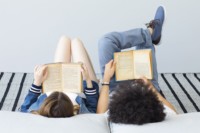 Dziewcczyna i chłopiec czytają książki leżąc na łóżku. Kliknięcie w miniaturkę obrazka spowoduje wyświetlenie powiększonego zdjęcia.