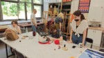 Cztery uczennice i Piotr Strobel (nauczyciel) pracują w czasie warsztatów w pracowni szkolnej (tkanina art). Kliknięcie w miniaturkę obrazka spowoduje wyświetlenie powiększonego zdjęcia.