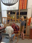 Uczennica i Piotr Strobel (nauczyciel) pracują w czasie warsztatów w pracowni szkolnej (tkanina art). Kliknięcie w miniaturkę obrazka spowoduje wyświetlenie powiększonego zdjęcia.