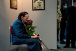 Adela Adamczyk siedzi na krześle w galerii szkolnej trzymając w rękach kwiat hortensji ogrodowej. Kliknięcie w miniaturkę obrazka spowoduje wyświetlenie powiększonego zdjęcia.