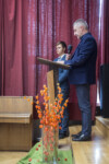 Krzysztof Dąbek przemawia przy mównicy w auli szkolnej. Obok niego stoi uczeń. Kliknięcie w miniaturkę obrazka spowoduje wyświetlenie powiększonego zdjęcia.