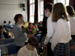 Uczniowie składają podziękowania i wręczają bukiet kwiatów v-ce dyr Alinie Tkaczyk. Uśmiecha się. Kliknięcie w miniaturkę obrazka spowoduje wyświetlenie powiększonego zdjęcia.
