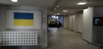 Na tablicy przy głównym wejście plakat z flagą ukraińską. W głębi, w holu szkoły punkt zbiórki darów dla ludności ukraińskiej i pomagający uczniowie. Kliknięcie w miniaturkę obrazka spowoduje wyświetlenie powiększonego zdjęcia.