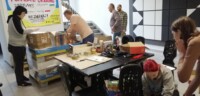 W holu szkoły uczniowie i pracownicy (dyr Krzysztof Dąbek, Wojciech Koryciński, Daniel Targoński) sortują dary i zapełnianiają paletę. Kliknięcie w miniaturkę obrazka spowoduje wyświetlenie powiększonego zdjęcia.